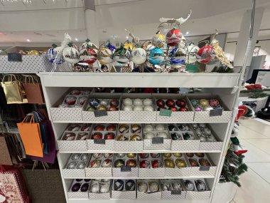 Varşova, Polonya - 20 Kasım 2025: Canlı Noel süsleri bir alışveriş merkezindeki raflarda düzenlenerek tatil sezonu için şenlikli bir ortam yaratıldı