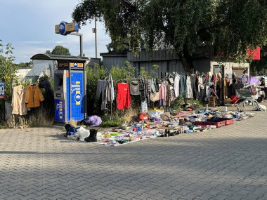 Varşova, Polonya - 28 Ekim 2025: Çitlere asılı giysiler ve çeşitli eşyalar ile canlı sokak pazarı, yerel kültür ve toplum yansır