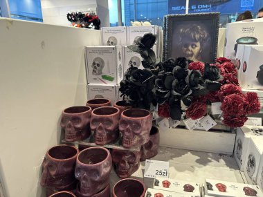 Varşova, Polonya - 28 Ekim 2025: Kafatası şekilli kupalar ve koyu çiçekli süslemeler çağdaş bir dükkanda düzenlenmiştir,