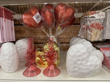 Varşova, Polonya - 28 Ocak 2026: Kalp şeklinde vazolar, kırmızı balonlar ve bir mağaza rafında düzenlenen parti malzemeleri içeren Sevgililer Günü süslemeleri