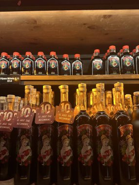 Ahşap raflarda dizilmiş çeşitli aromalı içecekler renkli etiketler ve özel teklifler için promosyon etiketleri ve fiyatlandırmalar.