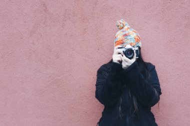 Klasik bir kamerayla fotoğraf çeken bir kız.