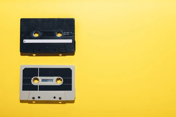 Two audio cassette tapes isolated on a yellow background. Copy space