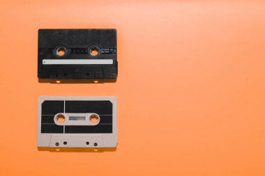 Turuncu arka planda izole edilmiş iki ses kaseti. Boşluğu kopyala