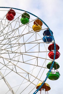 Panoramik manzaralı bir dönme dolap. Renkli kamaraları ve arka planında gökyüzü olan bir dönme dolap..