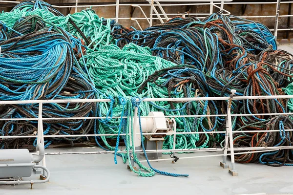 A huge number of ropes of various colors and thicknesses are thrown in heaps on the deck.