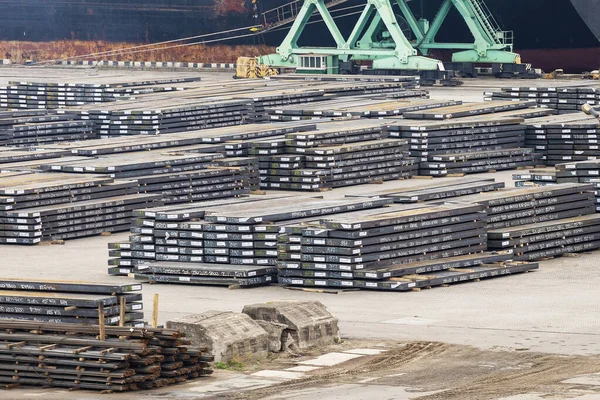 The rusty hot-rolled round steel bars in packs at the warehouse of metal products piled on the port site