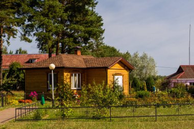 Yeşil ile çevrili küçük sarı ahşap bir ev.