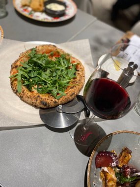 Pizzalı roka ve bir bardak kırmızı şarap.