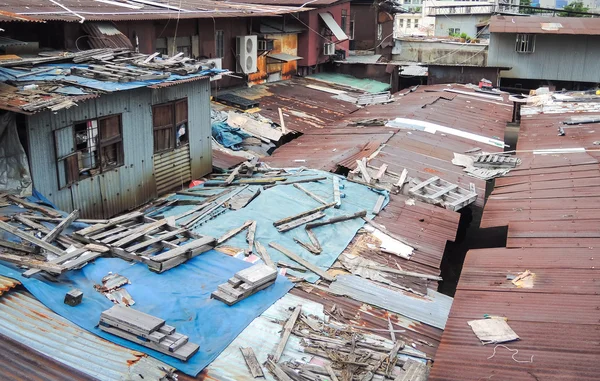 Antigua casa sucia en la azotea con palos de madera desordenados en la parte superior — Foto de Stock