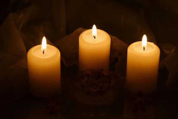 Kaarsen met bloemen en feestelijk tafellaken — Stockfoto