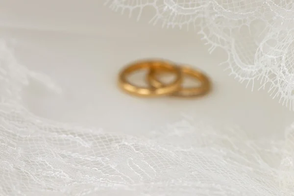 Біле весільне мереживо з золотими кільцями на задньому плані — стокове фото