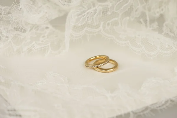 Golden wedding rings with embroidered lace — Stock Photo, Image