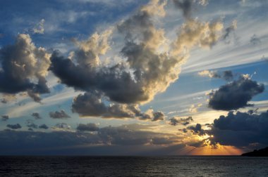 Gri bulutlarla deniz günbatımı