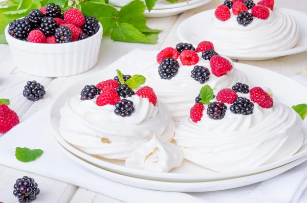 Pasteles de merengue Pavlova con crema batida y bayas frescas — Foto de Stock