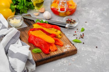 Gri beton arka planda terbiye edilmesini sağlayacak malzemelerin üzerine doğranmış dolmalık biber. Adım adım tarif