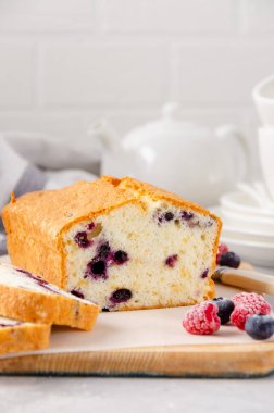 Üzerinde yaban mersini olan gri beton kaplama vanilyalı kek ya da sünger kek. Boşluğu kopyala