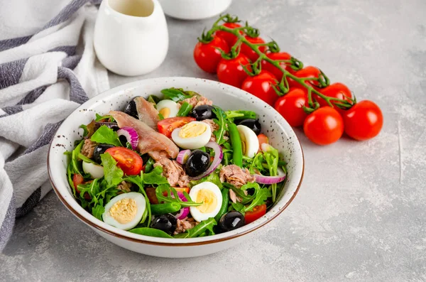 Ton balığı, yumurta, yeşil fasulye, domates, zeytin, marul, soğan ve ançüezli Fransız salatası. Sağlıklı yemek.