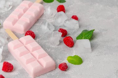 Ev yapımı ahududu dondurması ya da buzlu buzlu, gri beton arka planda yeşil nane yaprakları ve donmuş böğürtlenler. Üst görünüm, alanı kopyala