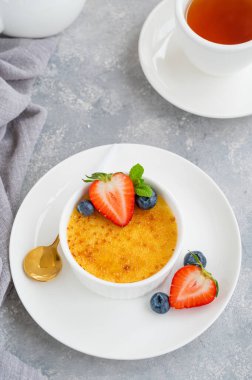 Creme brulee. Geleneksel Fransız vanilyalı kremalı tatlı üzerine karamelli şeker ve taze böğürtlen.