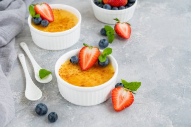 Creme brulee. Geleneksel Fransız vanilyalı kremalı tatlı üzerine karamelli şeker ve taze böğürtlen.