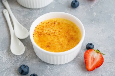 Creme brulee. Geleneksel Fransız vanilyalı kremalı tatlı üzerine karamelli şeker ve taze böğürtlen.