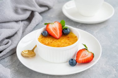 Creme brulee. Geleneksel Fransız vanilyalı kremalı tatlı üzerine karamelli şeker ve taze böğürtlen.