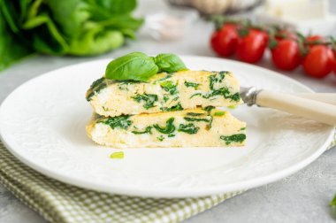 Ispanaklı omlet, yeşil soğan ve gri beton arka planda beyaz tabakta beyaz peynir. Sağlıklı kahvaltı. Boşluğu kopyala