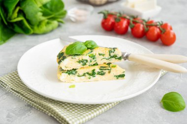 Ispanaklı omlet, yeşil soğan ve gri beton arka planda beyaz tabakta beyaz peynir. Sağlıklı kahvaltı. Boşluğu kopyala