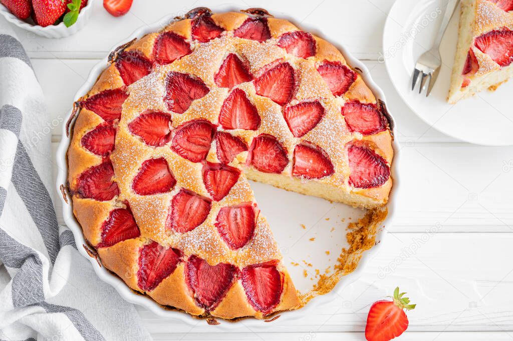 Strawberry vanilla sponge cake or pie on a white wooden background with fresh strawberries. Summer dessert. Copy space