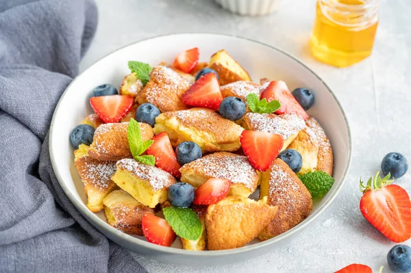 Kaiserschmarrn - gri beton arka planda taze böğürtlen ve pudra şekerli geleneksel Avustralya krep tatlısı. Güzel kahvaltı. Boşluğu kopyala