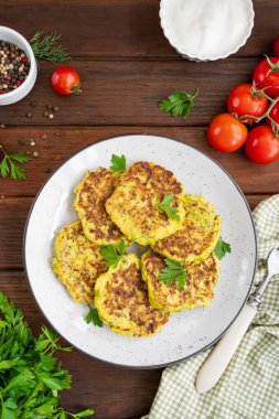 Sebzeli kabaklı krep, peynirli, dereotlu ve maydanozlu ve ekşi kremalı, siyah ahşap arka planda. Boşluğu kopyala.