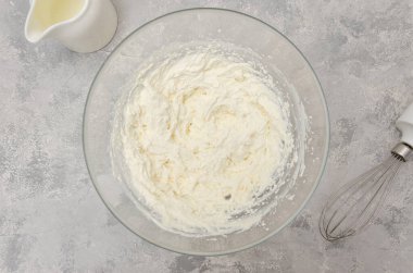 Krem peyniri bir kasede hazır et ki pastayı gri beton arka planda yapabilsin. Üst görünüm