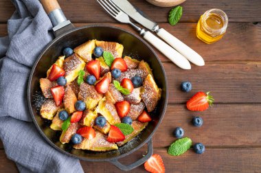 Kaiserschmarrn - koyu ahşap zemin üzerinde taze böğürtlen ve pudra şekerli geleneksel Avustralya krep tatlısı. Güzel kahvaltı. Boşluğu kopyala