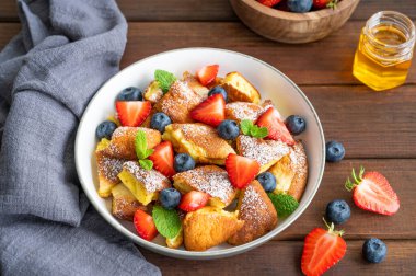 Kaiserschmarrn - koyu ahşap zemin üzerinde taze böğürtlen ve pudra şekerli geleneksel Avustralya krep tatlısı. Güzel kahvaltı. Boşluğu kopyala