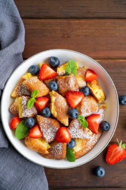 Kaiserschmarrn - koyu ahşap zemin üzerinde taze böğürtlen ve pudra şekerli geleneksel Avustralya krep tatlısı. Güzel kahvaltı. Boşluğu kopyala