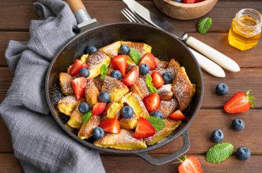 Kaiserschmarrn - koyu ahşap zemin üzerinde taze böğürtlen ve pudra şekerli geleneksel Avustralya krep tatlısı. Güzel kahvaltı. Boşluğu kopyala