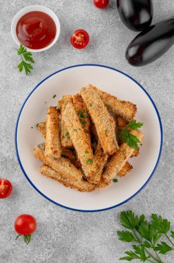 Gri beton arka planda bir tabakta domates sosuyla servis edilen haşlanmış patlıcan çubukları. Vejetaryen sağlıklı yemek. Seçici odak.