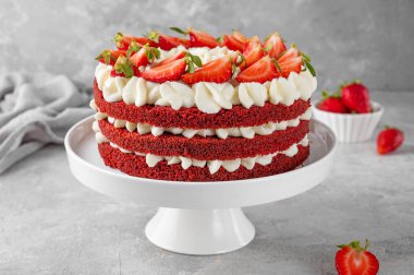 Çıplak kırmızı kadife kek ve taze çilek. Kırmızı sünger kekleri ve krem peynirli kremalı pastadan yapılan şenlikli bir pasta. Amerikan mutfağı.