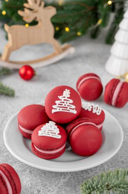 Noel ahududu kurabiyeleri, beton bir arka planda beyaz bir tabakta şeker jölesiyle süslenmiş. Bayramlık tatlı. Üst görünüm