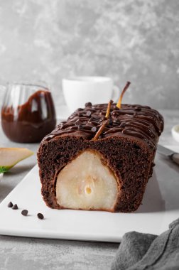 Çikolatalı turta ya da tam armutlu pasta ve gri arka planda çikolata jöleli pasta.