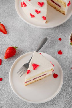 Sevgililer günü için küçük kırmızı kalpli vanilyalı çilekli pasta gri beton arka planda beyaz bir tabakta. Romantik pasta.