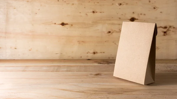 Paper bag on wooden background — Stock Photo, Image