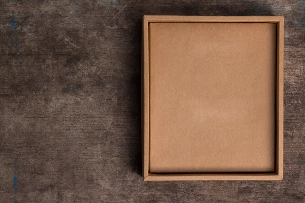Картонна коробка на дерев'яному фоні — стокове фото