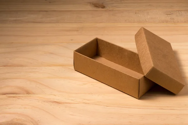 Caja de cartón abierta sobre fondo de madera — Foto de Stock
