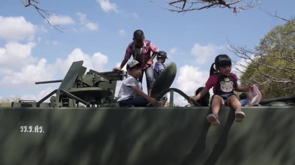 Les enfants sont assis sur le toit du réservoir. Garçon jouer avec la mitrailleuse — Video