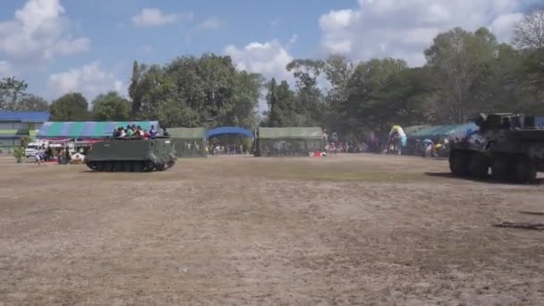 Reittank mit Kindern auf dem Dach und Panzerfahrzeug dahinter — Stockvideo