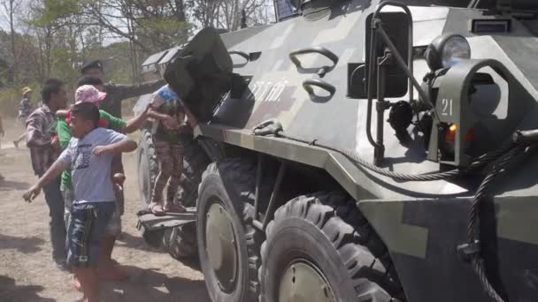 外出し、座る中の装甲車両に行くスローモーションの子供とその保護者 — ストック動画