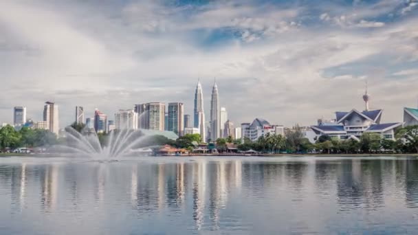 View of Petronas Towers Kuala Lumpur Time Lapse Malaysia daylight Titiwangsa Lake Menara, Fountain and People Kayaking on Titiwangsa Lake — Stock Video