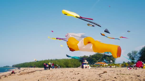 Urso de laranja inflável grande e pipa de sorriso voando na praia — Vídeo de Stock